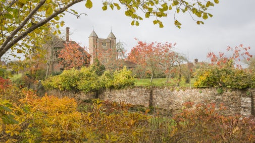 A view of the Elizabethan gatehouse tower from the autumnal gardens at Sissinghurst Castle Garden, Kent